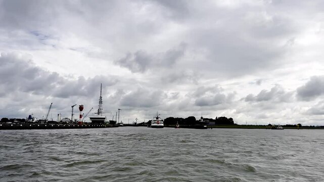 Entering a Maritime Hub Ferry Navigates the Busy Waters of Den Helder Harbor, a Vital Gateway to the North Sea, on a Cloudy Day