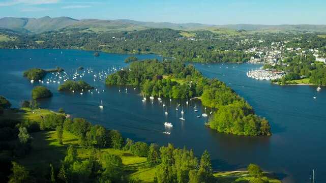 Windermere in the Lake District National Park, Cumbria, England. Aerial video fly in to N.E. over Belle Isle to Bowness marinas. Summer evening