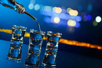 Vodka is poured into a shot glass. © Igor Normann