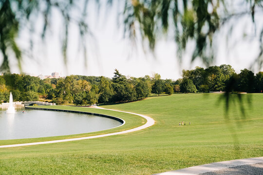 A Sunny Day at the Park With a Scenic View of a Fountain and Lake