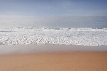 Calm Ocean Foam on Golden Sand at Praia da Adraga