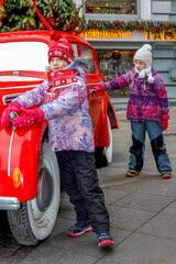 Obraz premium Two little toddler girls on a christmas market, outdoors. Happy children having fun. Holiday, lifestyle concept.