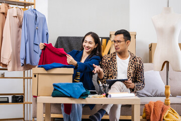 Businessman and woman, both fashion designers and entrepreneurs, happily designing clothes for...