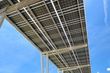 Obraz premium Solar panels installed over parking lot canopy shade for parked cars for effective generation of clean energy