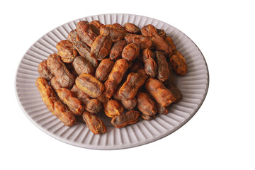 Sweet, spicy tamarind tree fruit in a round plate on a white background