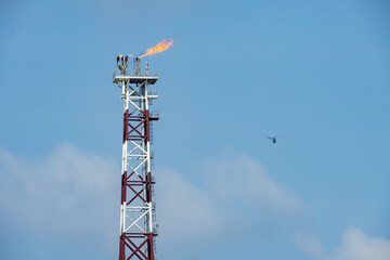 A helicopter about to land on an oil production platform for transferring of offshore crew at oil field