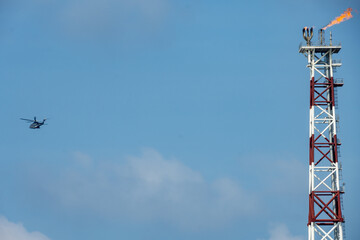 A helicopter about to land on an oil production platform for transferring of offshore crew at oil field