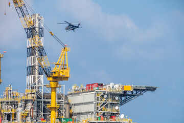 A helicopter about to land on an oil production platform for transferring of offshore crew at oil field