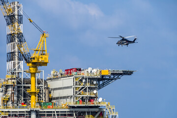 A helicopter about to land on an oil production platform for transferring of offshore crew at oil field