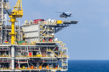 A helicopter about to land on an oil production platform for transferring of offshore crew at oil field. © wanfahmy