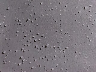Sparkling water drops on gray surface.