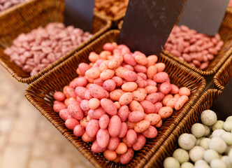 A basket of pink and orange candies sits on a table