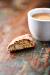 Cantuccini (Italian cookie) and a cup of coffee on dark wooden background. Close up.