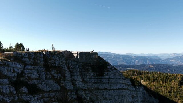 Scenic aerial view of Verena Fort located on Mount Verena, surrounded by stunning landscapes in the Italian Alps, featuring rugged cliffs, green forests, and expansive mountain views.