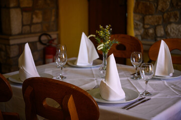 Elegant Table Setting with Fresh Flowers and Napkins in a Cozy Mediterranean Restaurant