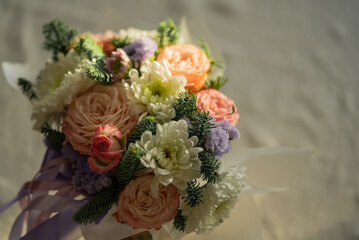 Beautiful bouquet featuring soft-colored roses, white chrysanthemums, small purple flowers, and fresh pine branches creates a lovely arrangement perfect for various occasions