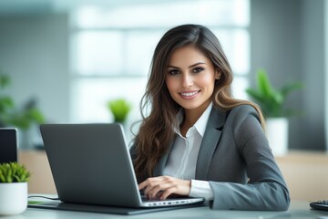Busy young business woman executive using laptop in office. Smiling businesswoman company employee sitting at work desk, professional female hr manager looking at pc computer at workplace
