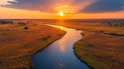 A vibrant river winding through surreal golden grasslands under a radiant orange sky