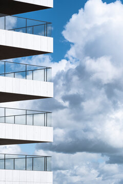 A striking photo capturing vibrant balconies adorned with greenery set against a dramatic cloudy sky, symbolizing the fusion of urban living and nature.
