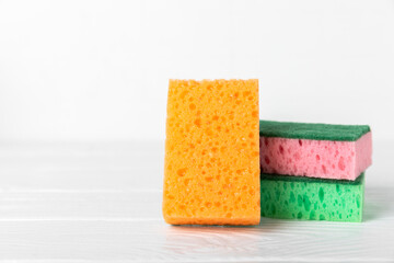 Colorful dish sponges on textured background. Kitchen sponge. Cleaning concept, cleaning service. Dishwashing liquid with clean and dirty dishes plate. Place for text, copy space. Wash the dishes.