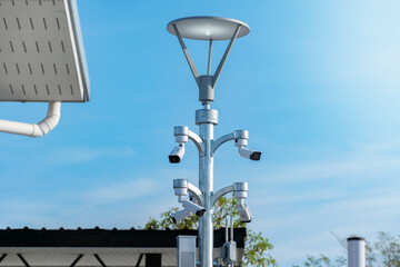 CCTV security system cameras installed on metal pole above the road and buildings to do and to save...