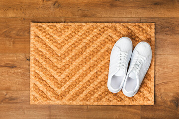 Doormat. Welcome mat on the floor background. Women's shoes on a doormat on background. Interior decor element in the hallway. Close-up. Space for text. Copy space.rug near the door in the hallway.