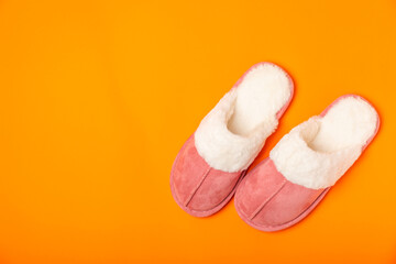 Soft slippers on a bright colored background, close-up. House slippers. Comfortable shoes for home. Foot care concept. Home comfort. Space for text. Copy space.