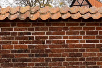 Brick wall around Frederiksborg Castle covered with a tiled roof