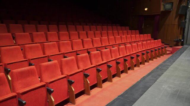 Wide view of empty theater hall with red seats