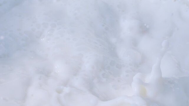 Almonds falling into milk, creating splashes and foam in slow motion 300fps