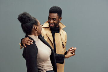 Happy couple dancing together in casual outfits, showcasing love and joy against a muted green background, perfect for relationship themes and lifestyle concepts