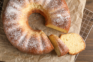 Freshly baked sponge cake on wooden table, top view