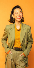 Cheerful young woman in fashionable clothes laughing on a bright clean background, showing a joyful expression on her face.