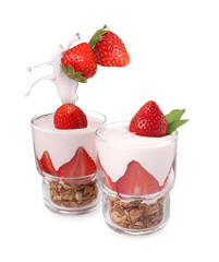 Fresh strawberries falling into glasses with yogurt and granola on white background