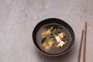 Traditional Japanese Miso soup with Wakame seaweed and tofu cheese with chopsticks for single serving. Vegetarian, vegan and healthy concept. Asian food.