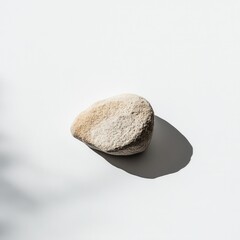 Smooth stone sunlit white background shadow