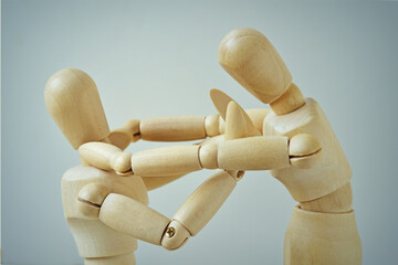 Violent wooden mannequin attacking weak one  - Concept of violence, bullying and prevarication
