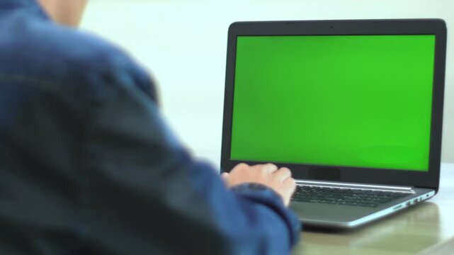 Man hands writing on green screen laptop sitting office close up. Unknown businessman typing document searching information surfing internet using mockup computer. Manager working on chroma key pc.