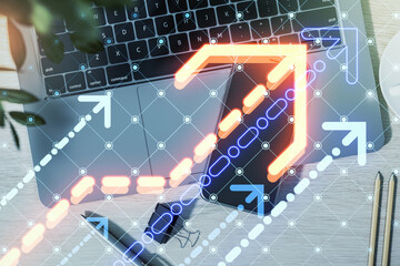 Digital arrows and geometric patterns over a laptop and smartphone on a desk.