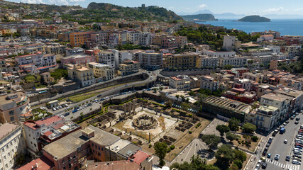 Obraz premium Aerial view the Macellum of Pozzuoli, near Naples, Italy. It was market building of the Roman colony of Puteoli. It was mistakenly known as the Temple of Serapis. In background is Nisida island.