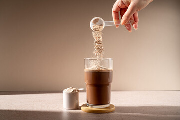 Protein shake and chocolate protein powder in a scoop, food supplement