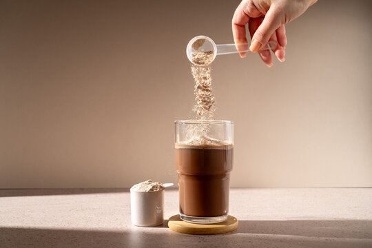 Protein shake and chocolate protein powder in a scoop, food supplement