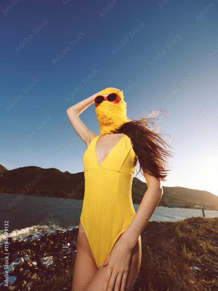 Sticker A woman in a yellow swimsuit and sunglasses standing near a serene body of water, exuding summer vibes and relaxation