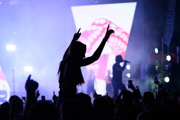 Concert-goer waving hands during vibrant live performance