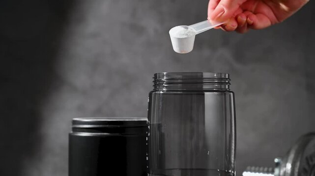 Amino acid food supplement, creatine powder in a measuring scoop and plastic jar