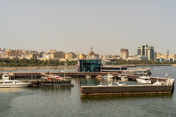Fototapeta premium A city with a large body of water and a marina full of boats. The water is calm and the sky is clear