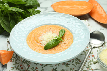 Delicious sweet potato soup served on white marble table, closeup