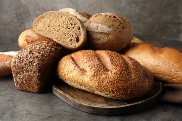 Different freshly baked bread loafs on grey table, closeup