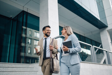 Business people walking and talking in front of office building