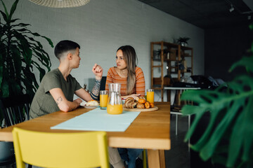 Lesbian couple having breakfast and talking at home